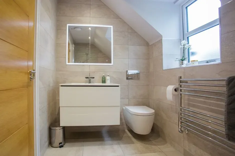WC suspendu Geberit avec cuvette sans bride fixée sur son bâti-support dans une salle de bains carrelée